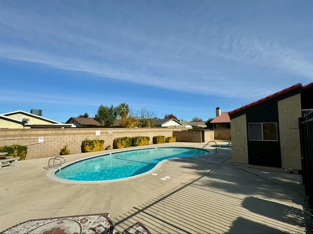 pool with a patio area and a fenced backyard