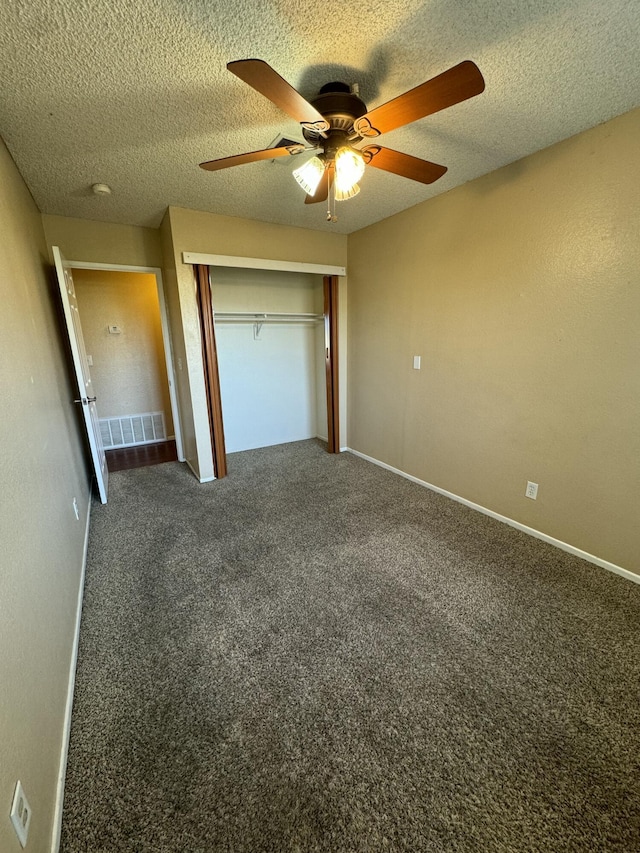 unfurnished bedroom with visible vents, a ceiling fan, a textured ceiling, carpet floors, and a closet