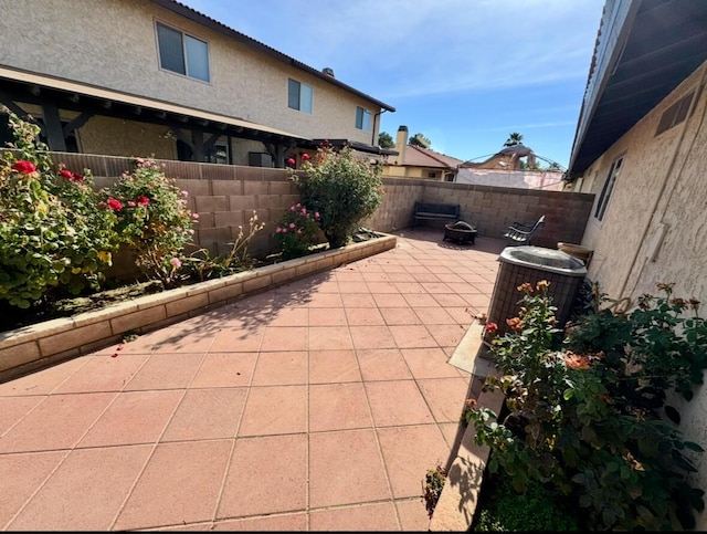 view of patio / terrace with an outdoor fire pit, a fenced backyard, and cooling unit