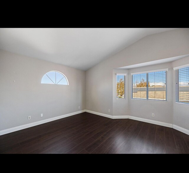 empty room featuring dark hardwood / wood-style floors and vaulted ceiling