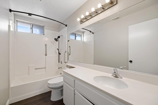 full bathroom featuring washtub / shower combination, wood-type flooring, toilet, and a wealth of natural light