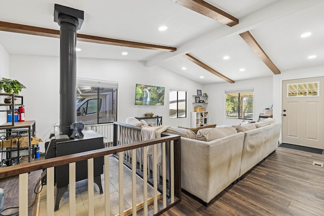 living room with dark wood-style flooring, a wood stove, recessed lighting, vaulted ceiling with beams, and visible vents