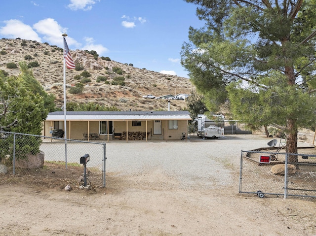 view of front of property with fence, a mountain view, and metal roof