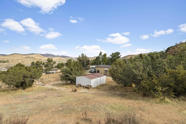 exterior space with a mountain view, an outdoor structure, and an outbuilding