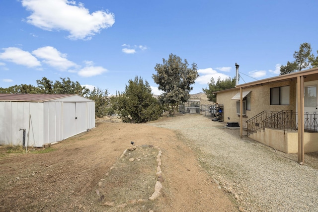 view of yard featuring a storage unit and an outbuilding
