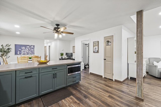 kitchen featuring dark wood-style flooring, ceiling fan, light countertops, recessed lighting, and stainless steel microwave