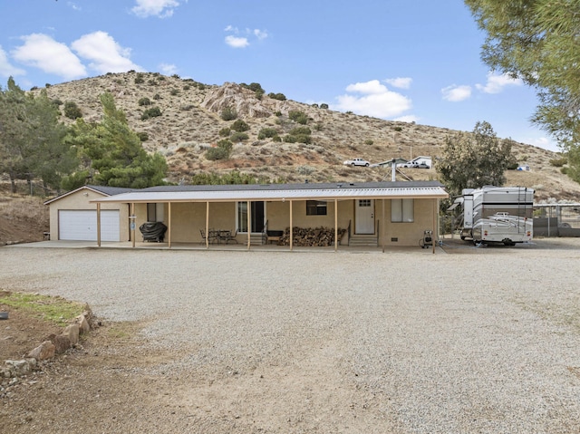 view of front of property featuring a mountain view, driveway, a detached garage, and entry steps