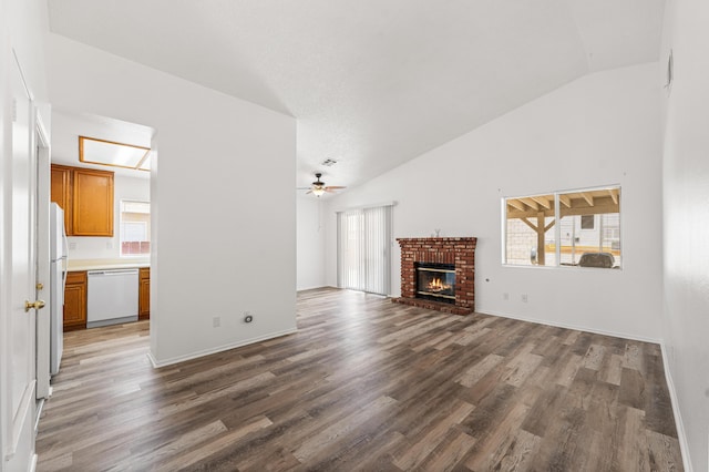 3243 Geri Ct, Rosamond, CA 93560 - unfurnished living room with vaulted ceiling, a ceiling fan, healthy amount of natural light, wood finished floors, and a brick fireplace