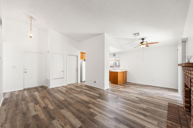 3243 Geri Ct, Rosamond, CA 93560 - unfurnished living room featuring ceiling fan, wood finished floors, a fireplace, vaulted ceiling, and baseboards