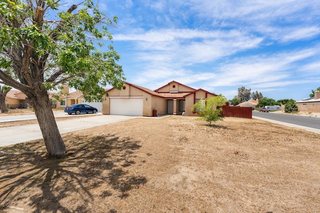 3243 Geri Ct, Rosamond, CA 93560 - view of front of home with a garage, concrete driveway, stucco siding, and fence