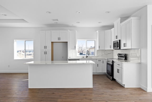 kitchen featuring a kitchen island, a sink, plenty of natural light, and stainless steel appliances