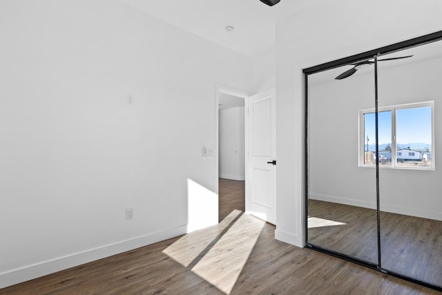 unfurnished bedroom with ceiling fan, a closet, baseboards, and wood finished floors