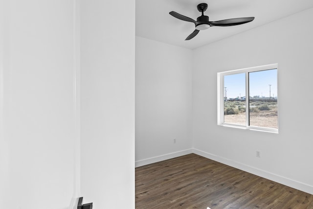 empty room featuring a ceiling fan, baseboards, and dark wood-style floors
