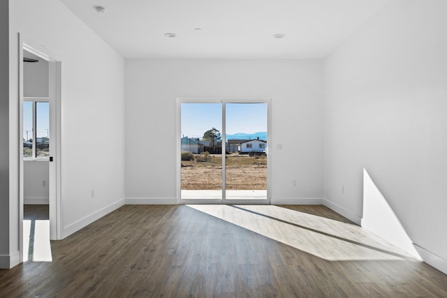 unfurnished room with baseboards and wood finished floors