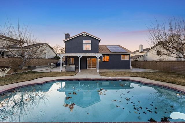 pool at dusk with central air condition unit and a patio