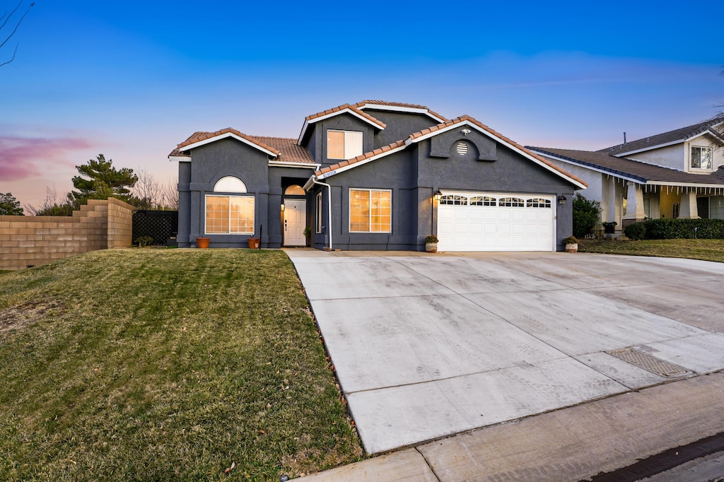 view of property featuring a garage and a lawn