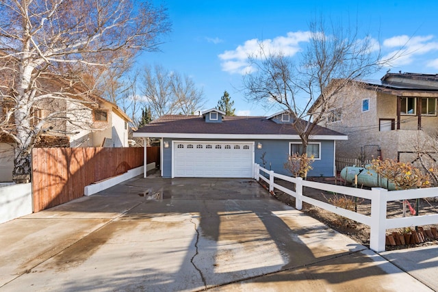 view of front of property with a garage, driveway, and a fenced front yard