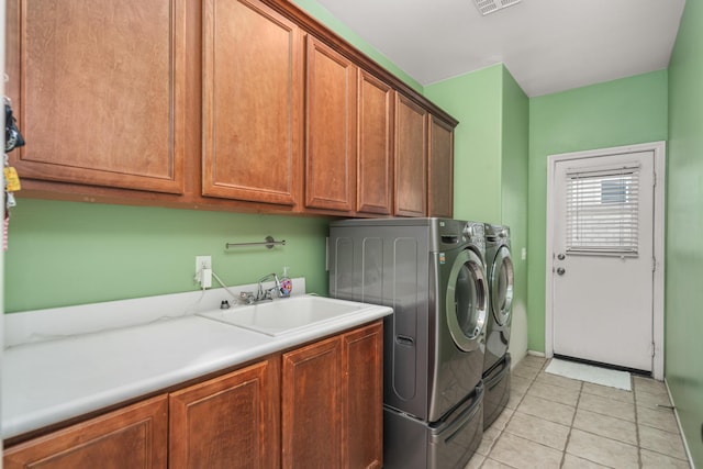 laundry room with cabinets, light tile patterned floors, washer and clothes dryer, and sink