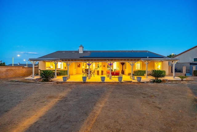 view of front of home with solar panels and a patio area