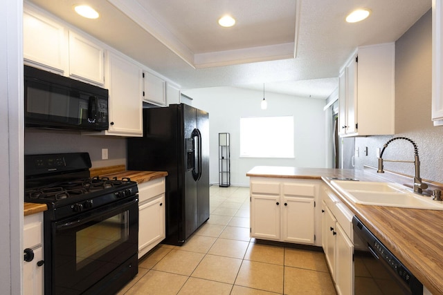 kitchen featuring a peninsula, white cabinets, a sink, wood counters, and black appliances