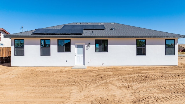 rear view of property with solar panels