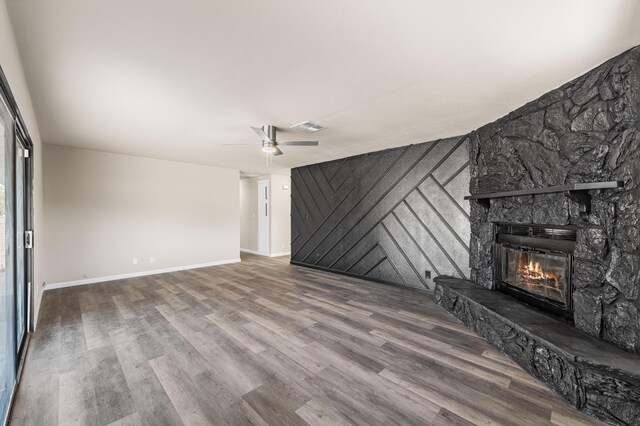 unfurnished living room featuring visible vents, wood finished floors, a ceiling fan, and a fireplace