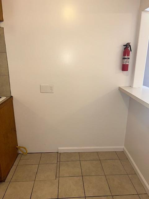 interior space featuring light tile patterned flooring and baseboards