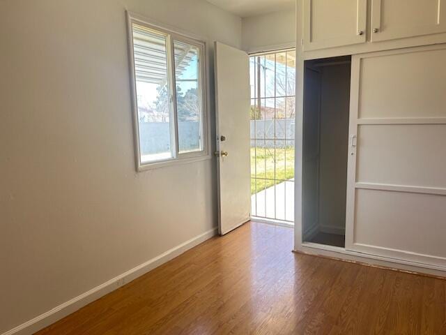 doorway to outside featuring baseboards and wood finished floors