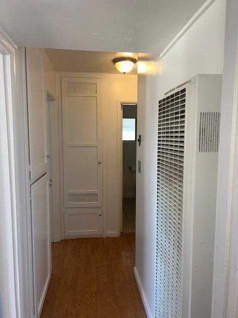 hallway featuring a heating unit and wood finished floors