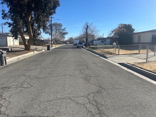 view of road with a residential view, curbs, sidewalks, and street lighting