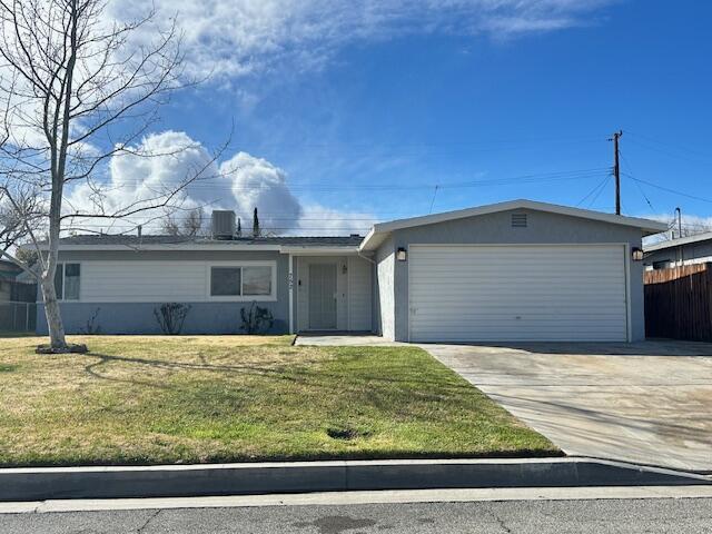 ranch-style home with fence, a front yard, central AC unit, driveway, and an attached garage