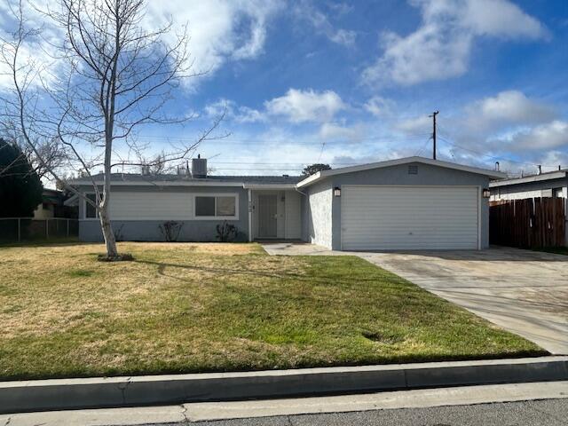 single story home featuring driveway, a front lawn, an attached garage, and fence