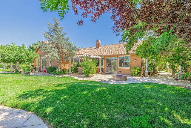 back of house with a yard, a patio, and a fire pit