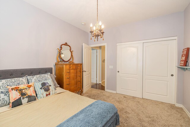 carpeted bedroom with a closet and a chandelier