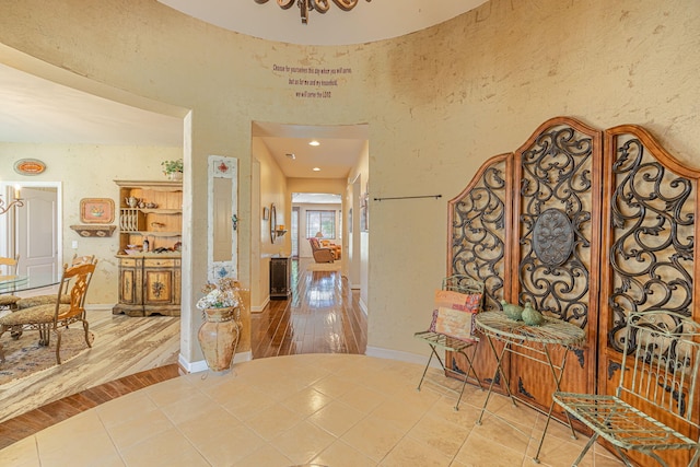 corridor featuring an inviting chandelier and tile patterned floors