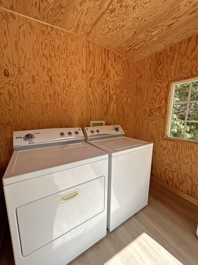 clothes washing area featuring light hardwood / wood-style floors and independent washer and dryer