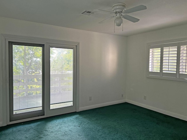 carpeted empty room featuring ceiling fan and a wealth of natural light