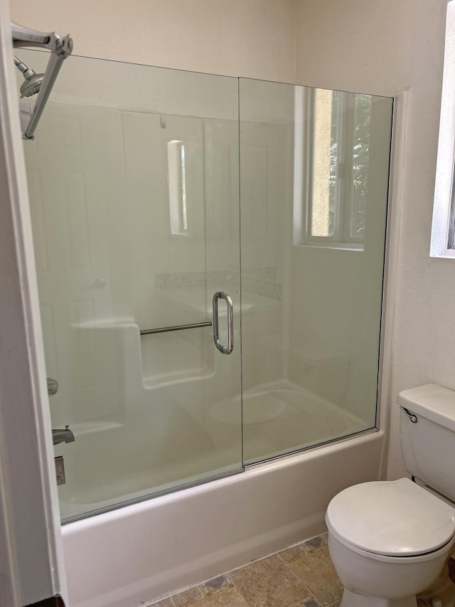 bathroom featuring toilet and enclosed tub / shower combo