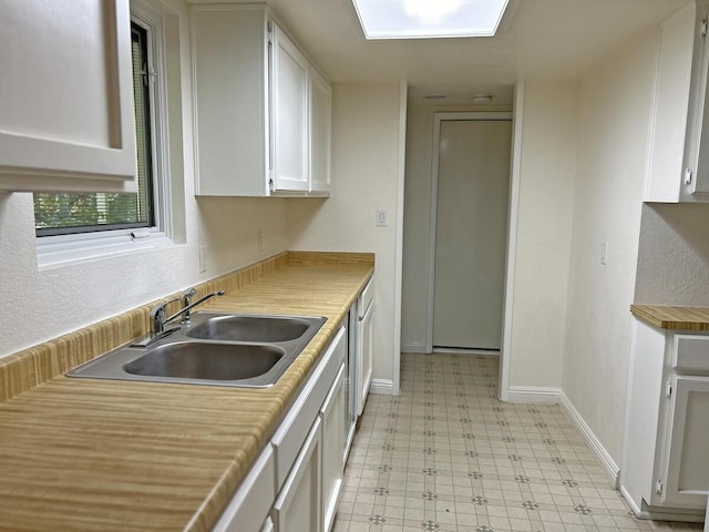 kitchen featuring dishwasher, sink, and white cabinets