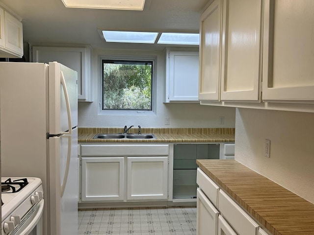 kitchen with white cabinets, white appliances, and sink