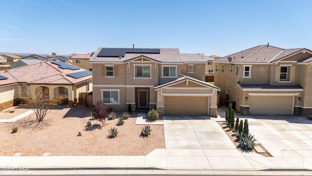 2022 Howard St, Rosamond, CA 93560 - view of front of home featuring stucco siding, concrete driveway, stone siding, roof mounted solar panels, and an attached garage
