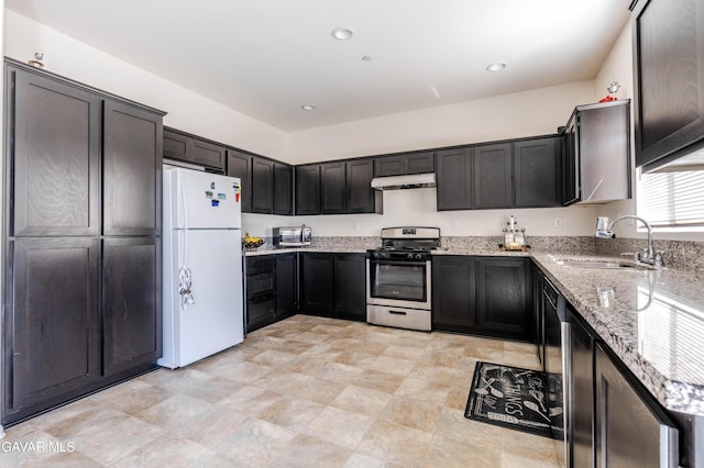 2022 Howard St, Rosamond, CA 93560 - kitchen featuring stainless steel range with gas stovetop, freestanding refrigerator, under cabinet range hood, light stone countertops, and recessed lighting