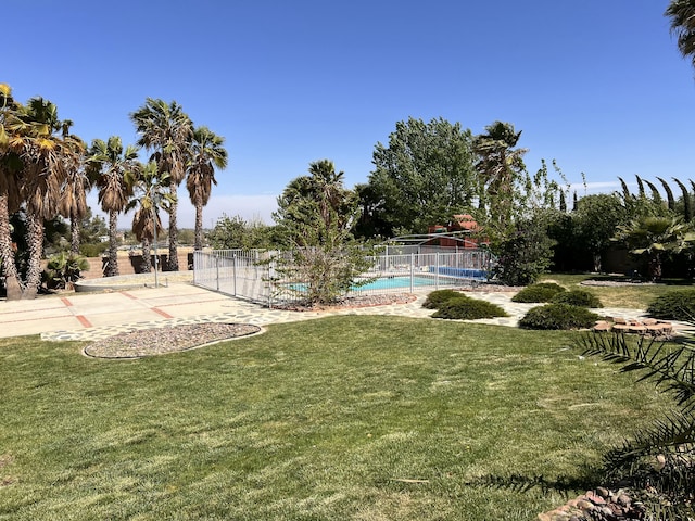 view of yard with a patio area, fence, and a fenced in pool