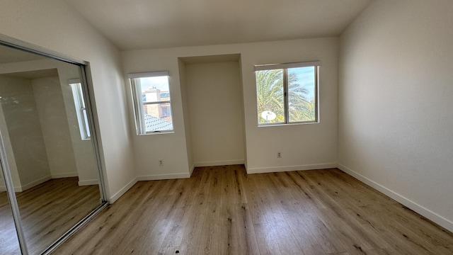 spare room featuring light wood-type flooring and baseboards