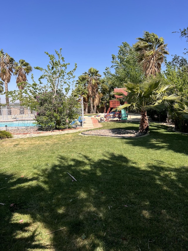 view of yard featuring a fenced in pool and playground community