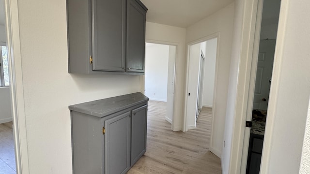 hall with light wood-type flooring and baseboards