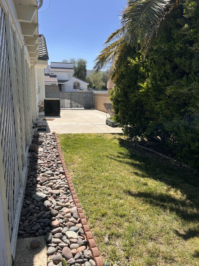 view of yard featuring a patio area, fence, and cooling unit