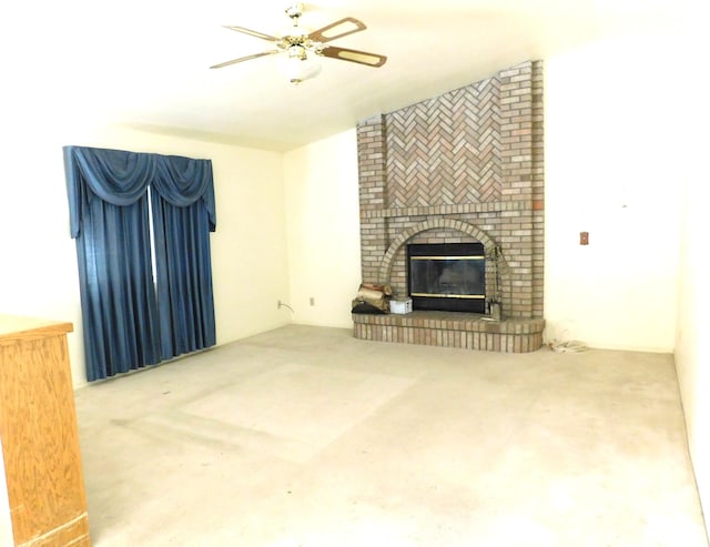 unfurnished living room with ceiling fan and a brick fireplace