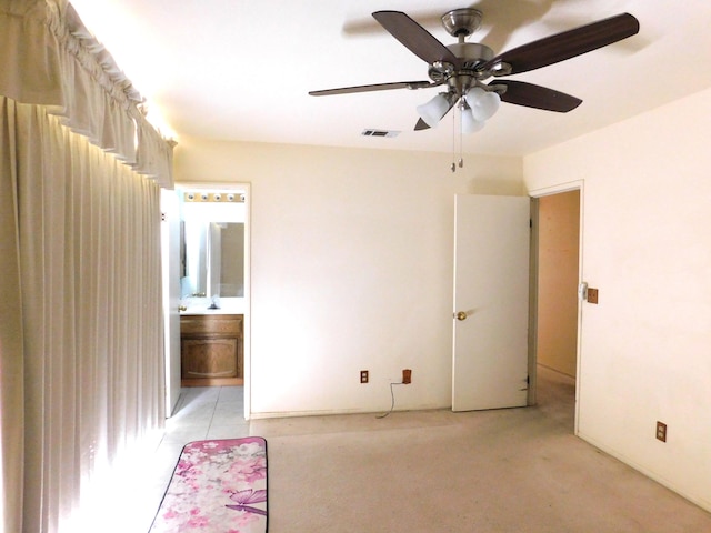 unfurnished bedroom featuring ceiling fan and ensuite bath