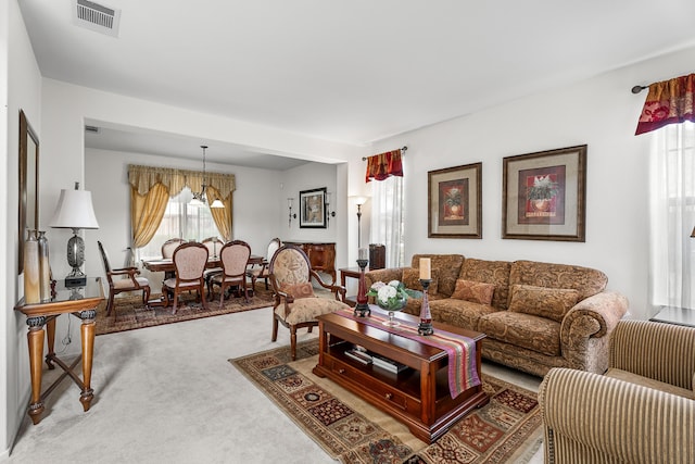 living room featuring a chandelier and carpet floors